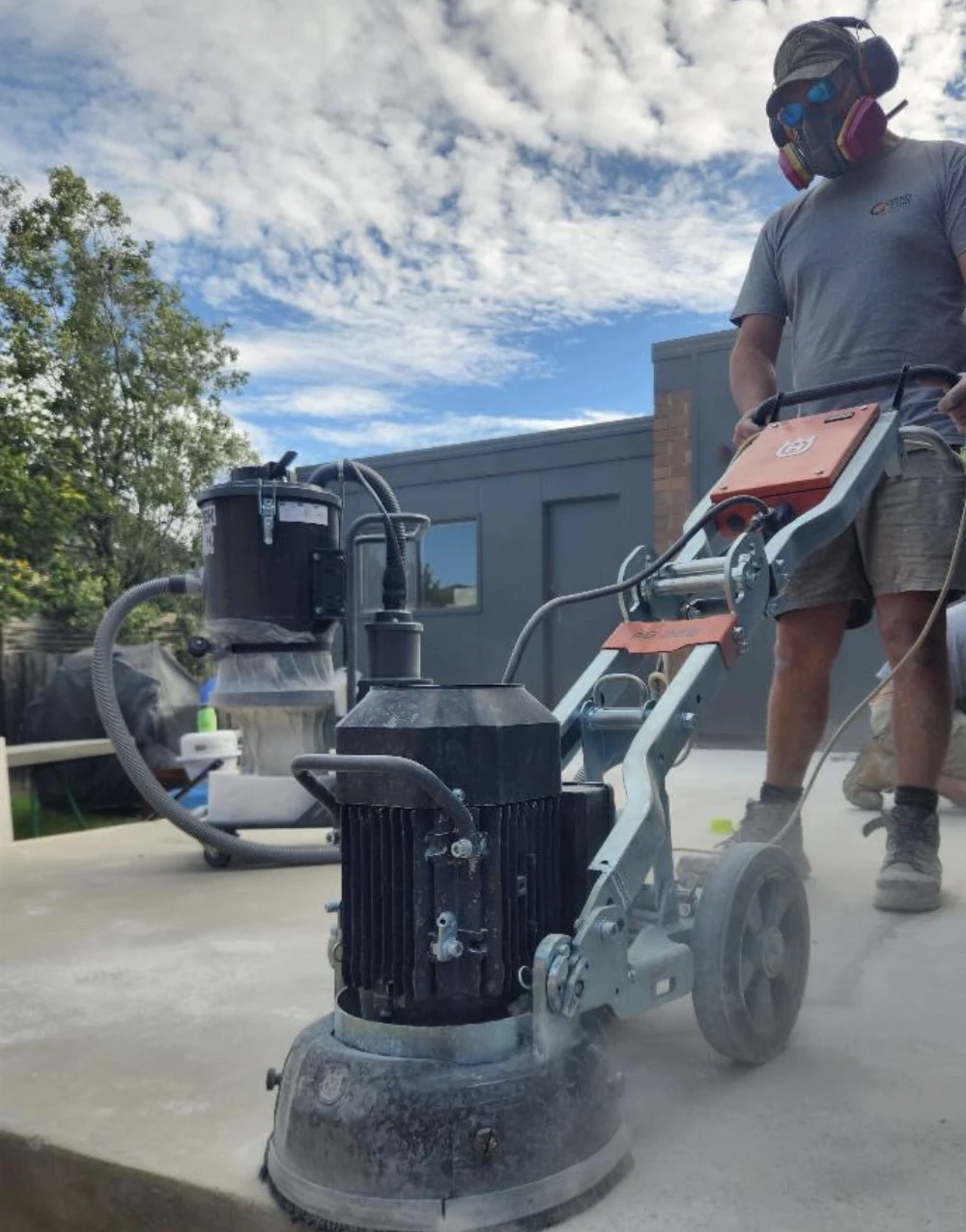 A worker operating a concrete grinder outdoors